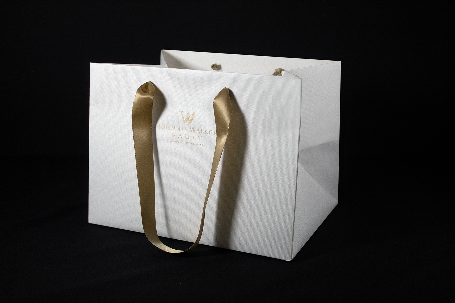 Johnnie Walker Vault Luxury paper carrier bags manufactured using Colorplan Bright White Embossed stock with gold foil branding and ribbon handles