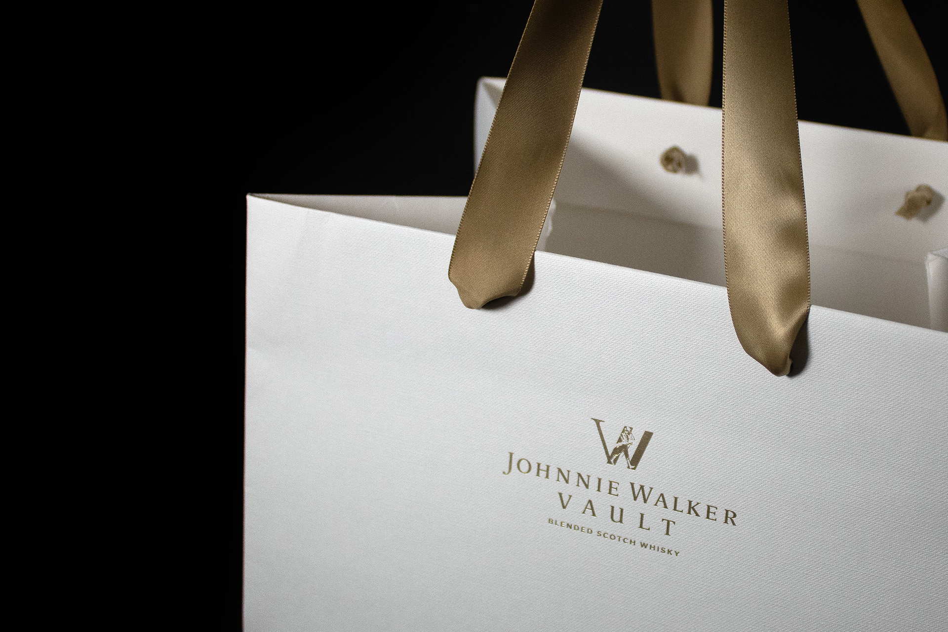 Johnnie Walker Vault Luxury paper carrier bags manufactured using Colorplan Bright White Embossed stock with gold foil branding and ribbon handles